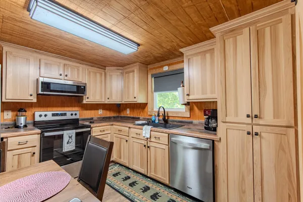 a kitchen with stainless steel appliances a sink stove refrigerator and cabinets