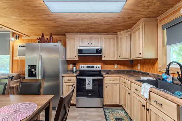 a kitchen with stainless steel appliances granite countertop a stove refrigerator sink and cabinets