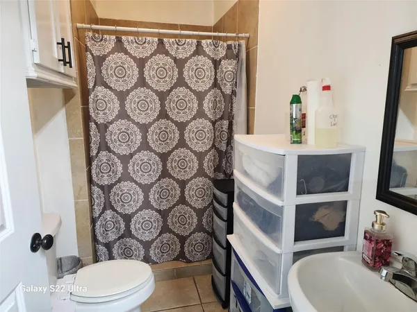 a bathroom with a toilet and shower curtain