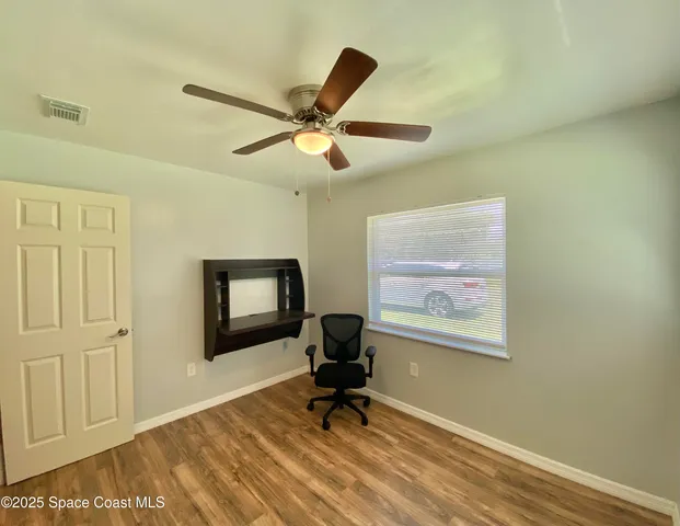 a living room with furniture and a ceiling fan