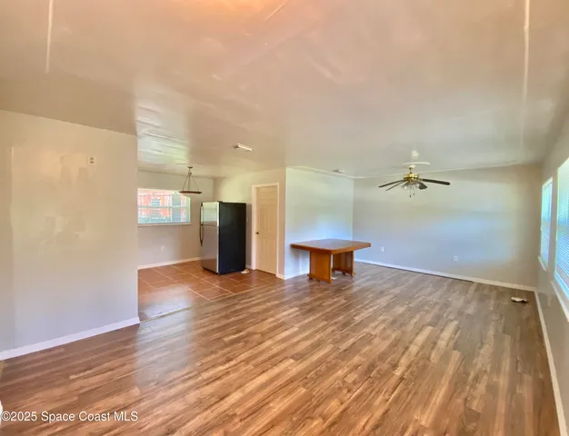 a view of a room with wooden floor and a bench