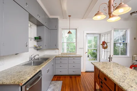 a kitchen with granite countertop a sink and a stove