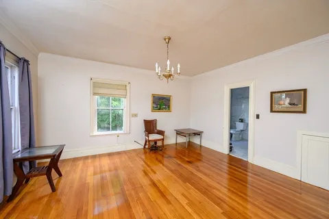 a view of a livingroom with furniture a window and wooden floor
