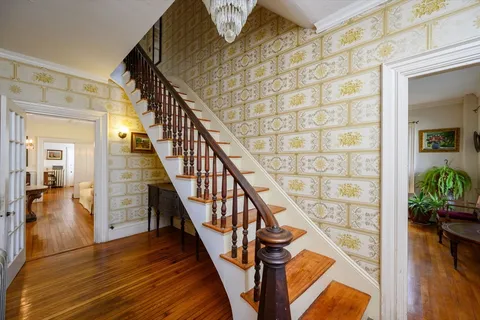 a view of entryway and hall with wooden floor