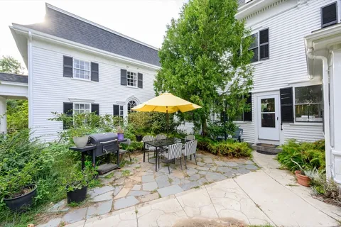 a view of a house with backyard sitting area and garden