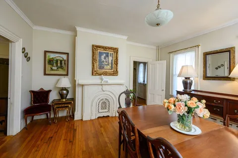 a view of a dining room with furniture a chandelier and wooden floor