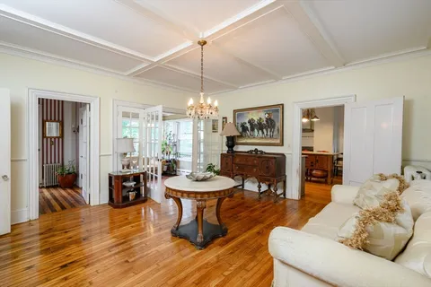 a living room with furniture a dining table and a chandelier