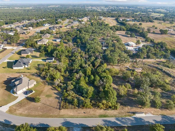 an aerial view of a house with a yard and lake view