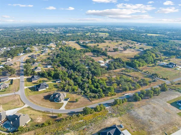 an aerial view of a city with lots of residential buildings ocean and mountain view in back
