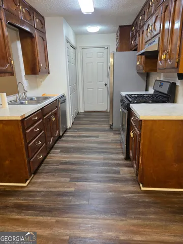 a kitchen with stainless steel appliances granite countertop a stove a sink and a refrigerator