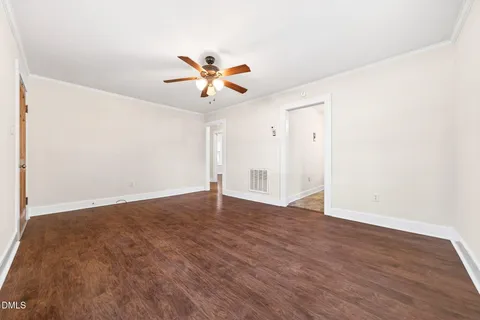 a view of an empty room with wooden floor