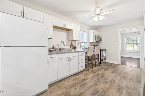 a kitchen with a refrigerator and white cabinets