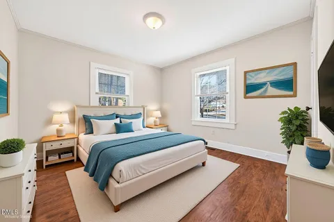 a spacious bedroom with a bed and a potted plant