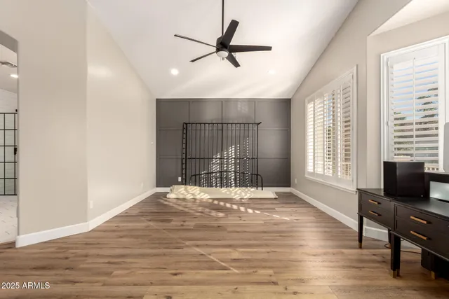an empty room with wooden floor and windows