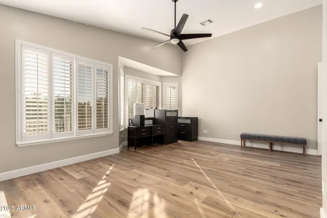 a view of a big room with windows and chandelier fan
