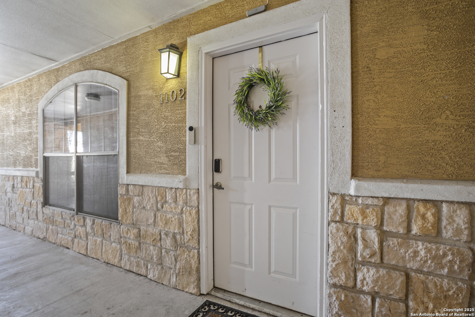 a view of a hallway with wooden floor and a glass door