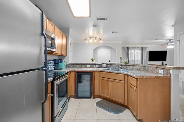 a kitchen with stainless steel appliances granite countertop a sink and a refrigerator