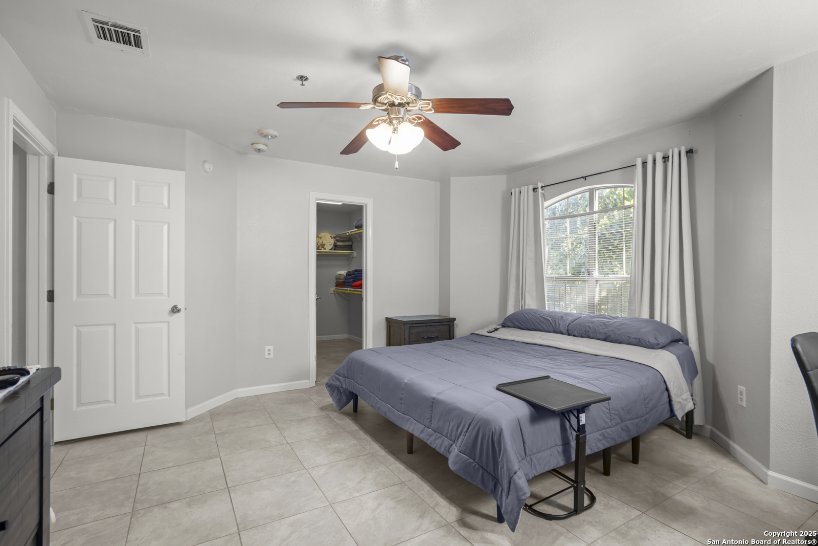 7323 Snowden Road, Unit 1102 San Antonio, TX 78229 - Photo 16 of 27 a bedroom with a bed and a chandelier