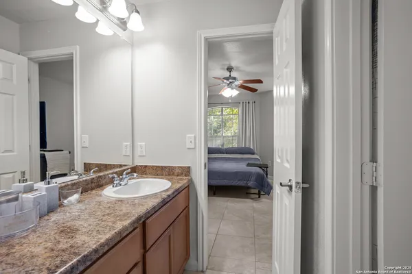 a en suite bathroom with a granite countertop sink a mirror and a vanity