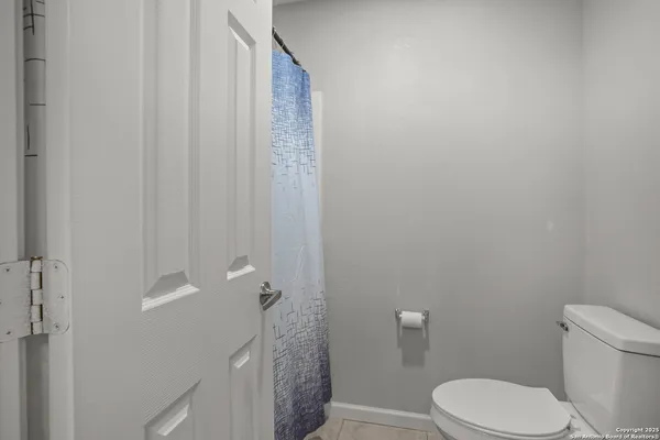 a white toilet sitting next to a shower curtain