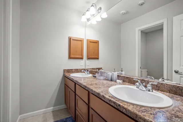 a bathroom with a granite countertop sink and a mirror
