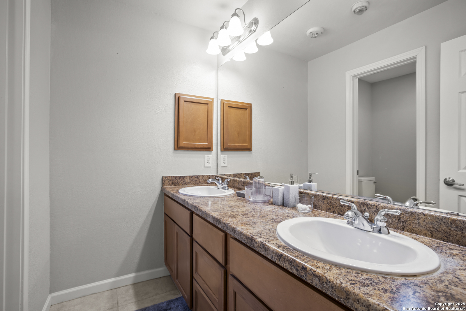 7323 Snowden Road, Unit 1102 San Antonio, TX 78229 - Photo 19 of 27 a bathroom with a granite countertop sink and a mirror