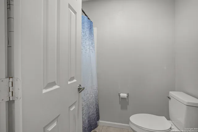 a white toilet sitting next to a shower curtain