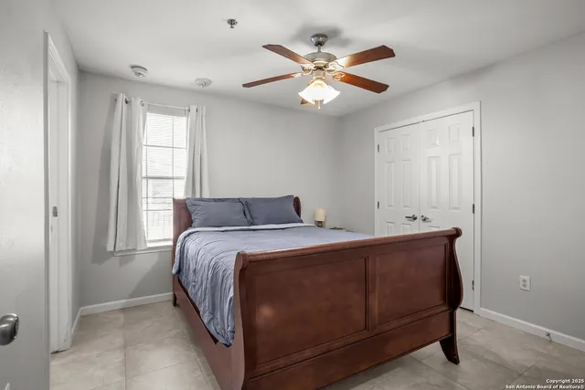 a bed room with a bed and a ceiling fan