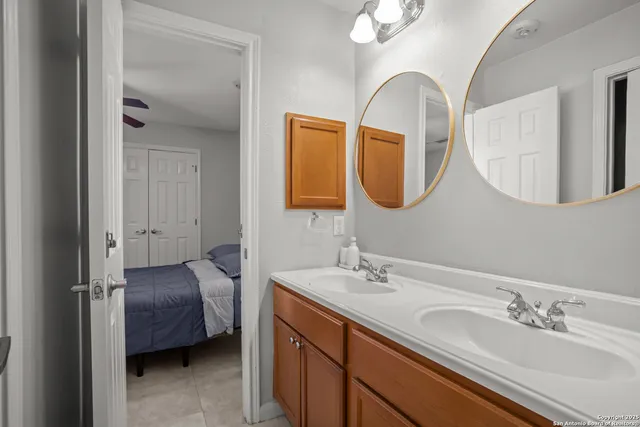 a en suite bathroom with a double vanity sink and a mirror