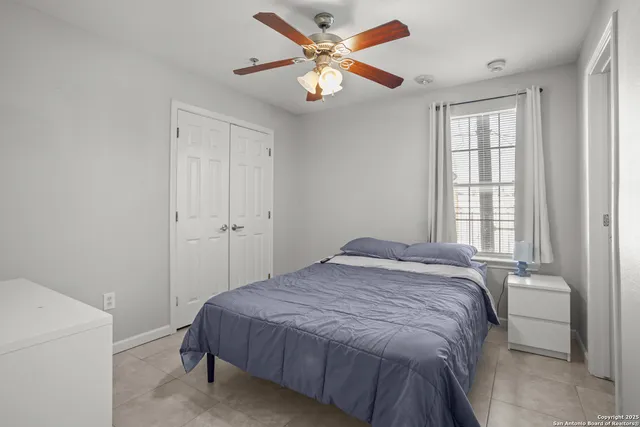 a bedroom with a bed and a ceiling fan