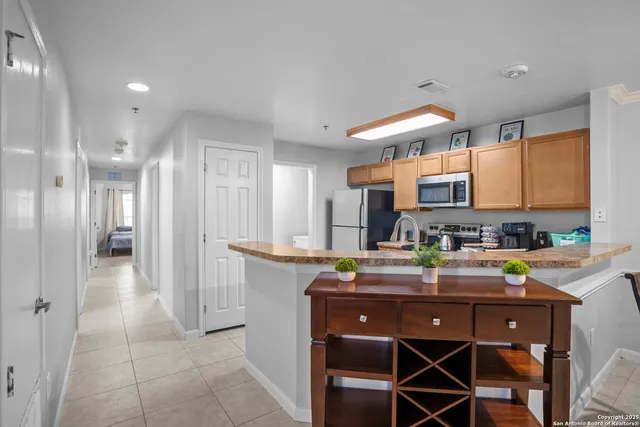 a kitchen with stainless steel appliances granite countertop a refrigerator and a sink