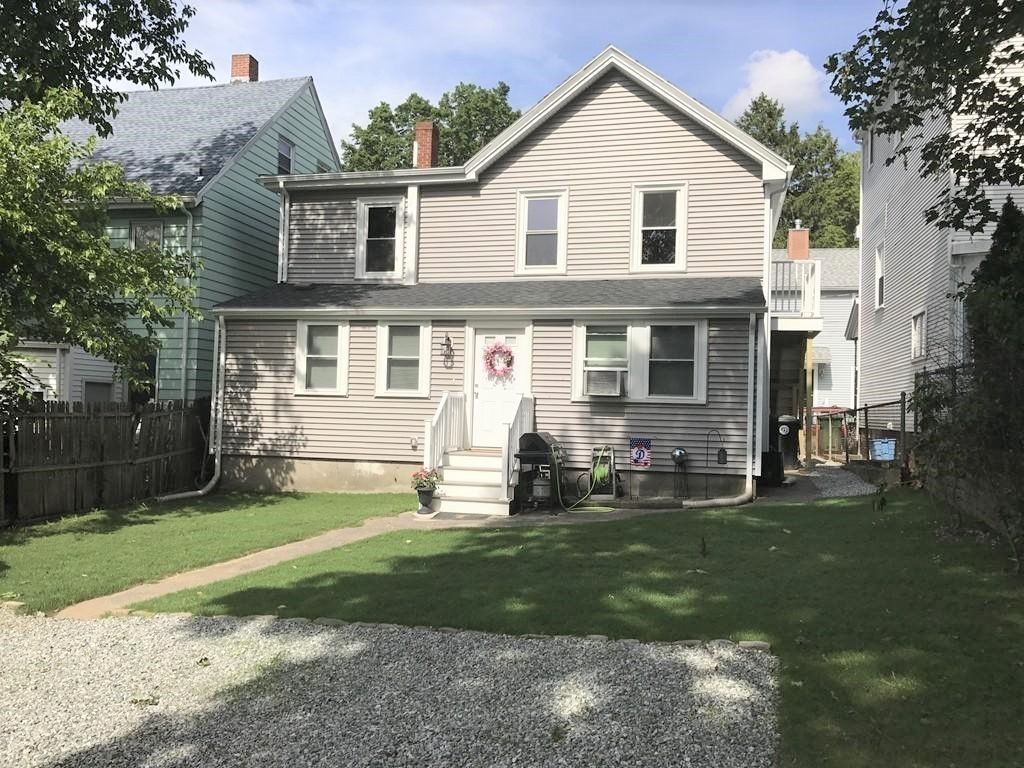 a front view of a house with a yard and trees