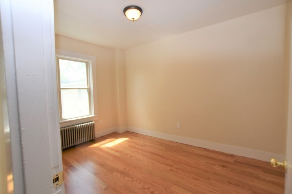 25 Sawin Street, Unit 25 Watertown, MA 02472 - Photo 18 of 22 an empty room with wooden floor and windows