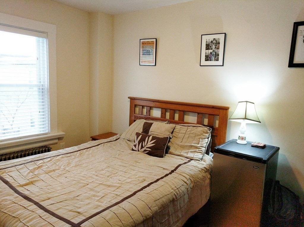 25 Sawin Street, Unit 25 Watertown, MA 02472 - Photo 19 of 22 a bedroom with a bed and wooden floor