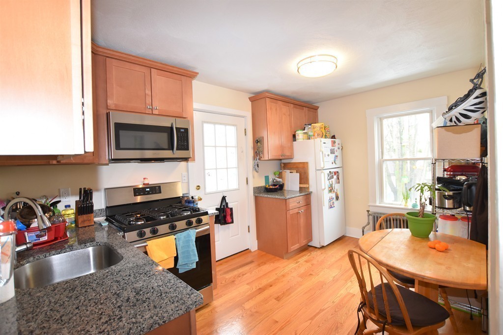 25 Sawin Street, Unit 25 Watertown, MA 02472 - Photo 3 of 22 a kitchen with a refrigerator a stove a sink dishwasher and wooden cabinets with wooden floor