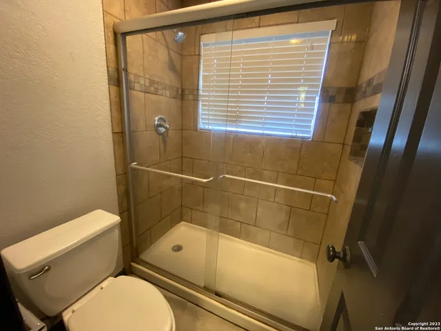a bathroom with a toilet and a shower