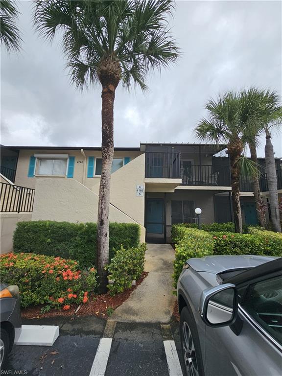 4140 Looking Glass Lane, Unit 5 Naples, FL 34112 - Photo 1 of 24 front view of house with a yard and palm trees