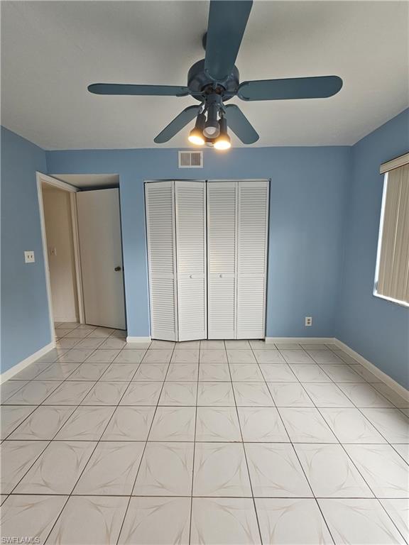 4140 Looking Glass Lane, Unit 5 Naples, FL 34112 - Photo 14 of 24 a view of an empty room and window and chandelier fan