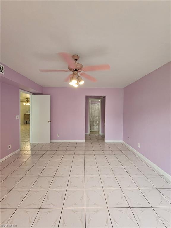 4140 Looking Glass Lane, Unit 5 Naples, FL 34112 - Photo 18 of 24 a view of an empty room with window and chandelier fan