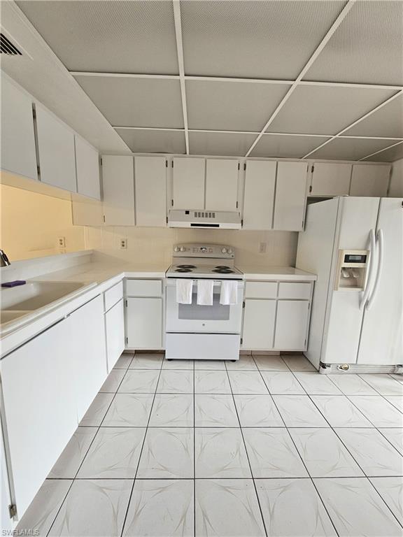 4140 Looking Glass Lane, Unit 5 Naples, FL 34112 - Photo 9 of 24 a kitchen with a stove sink and cabinets