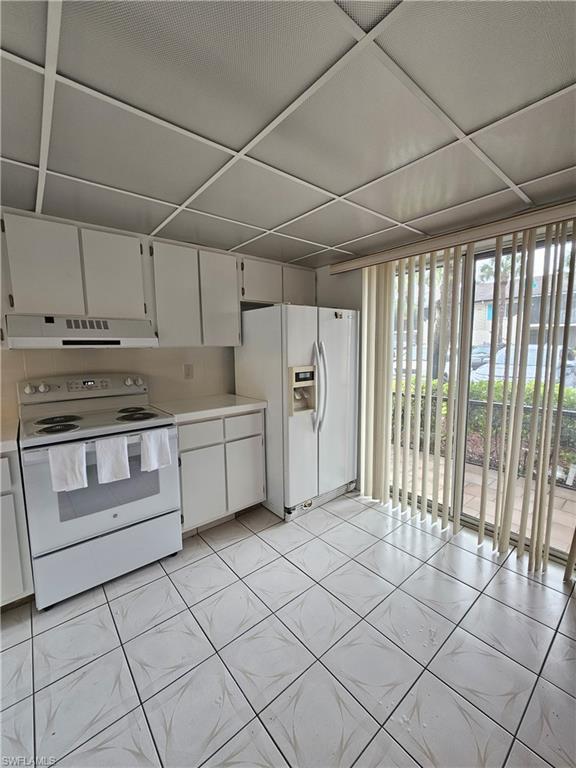4140 Looking Glass Lane, Unit 5 Naples, FL 34112 - Photo 10 of 24 a kitchen with white cabinets and white appliances