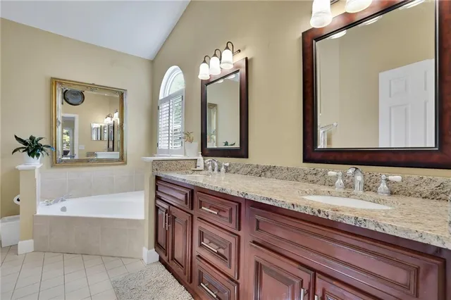 a bathroom with a granite countertop double vanity sink and a mirror