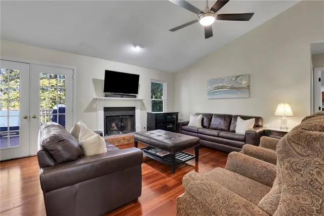 a living room with furniture a flat screen tv and a fireplace