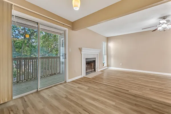 a view of empty room with wooden floor and fireplace
