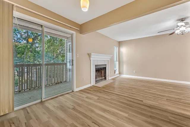 a view of empty room with wooden floor and fireplace