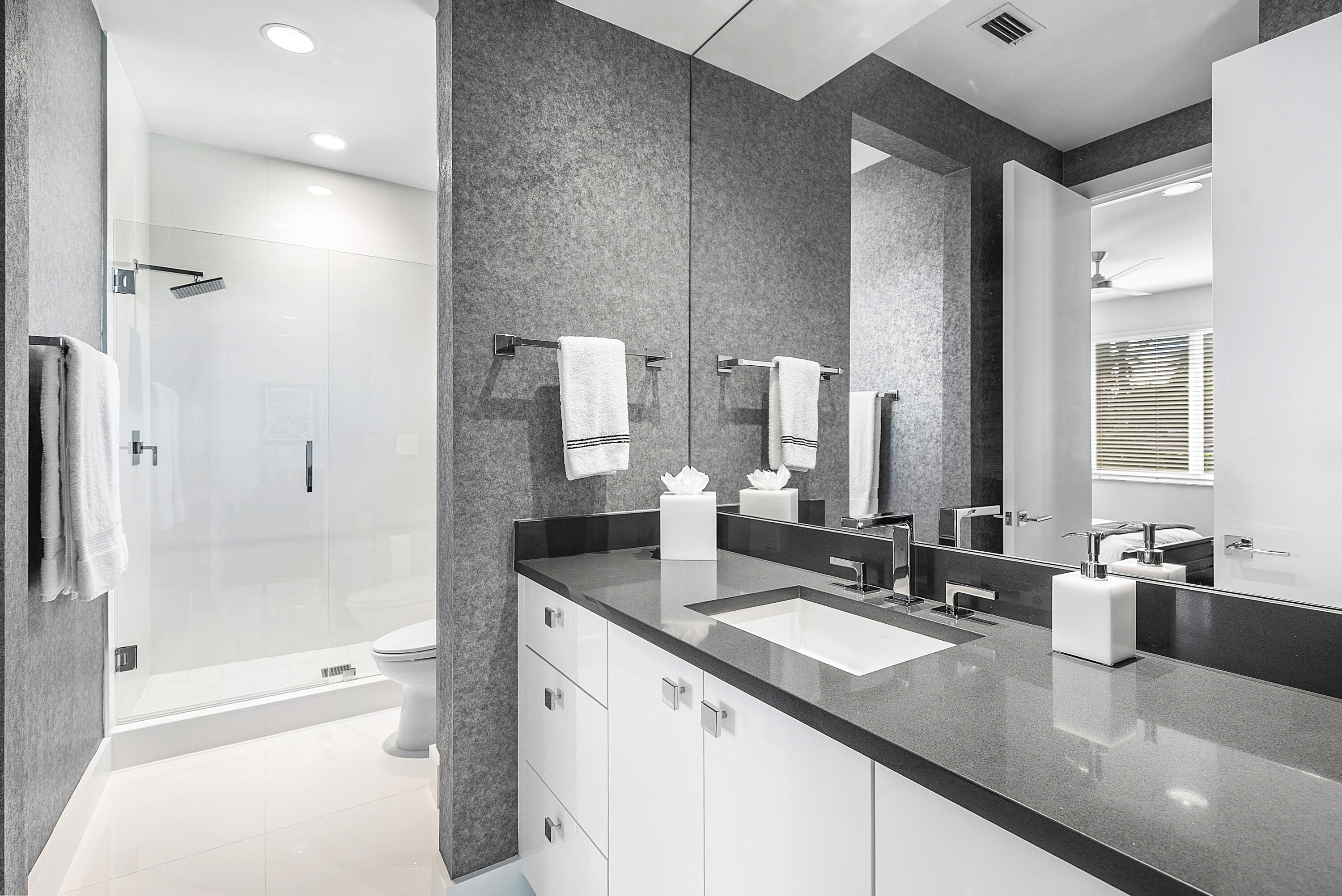 3710 Northwest 53rd Street Boca Raton, FL 33496 - Photo 27 of 42 a bathroom with a granite countertop sink a toilet a large mirror and shower