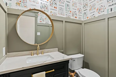 a bathroom with a toilet a sink and mirror