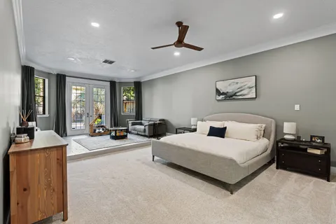 a spacious bedroom with a bed a couch and large windows