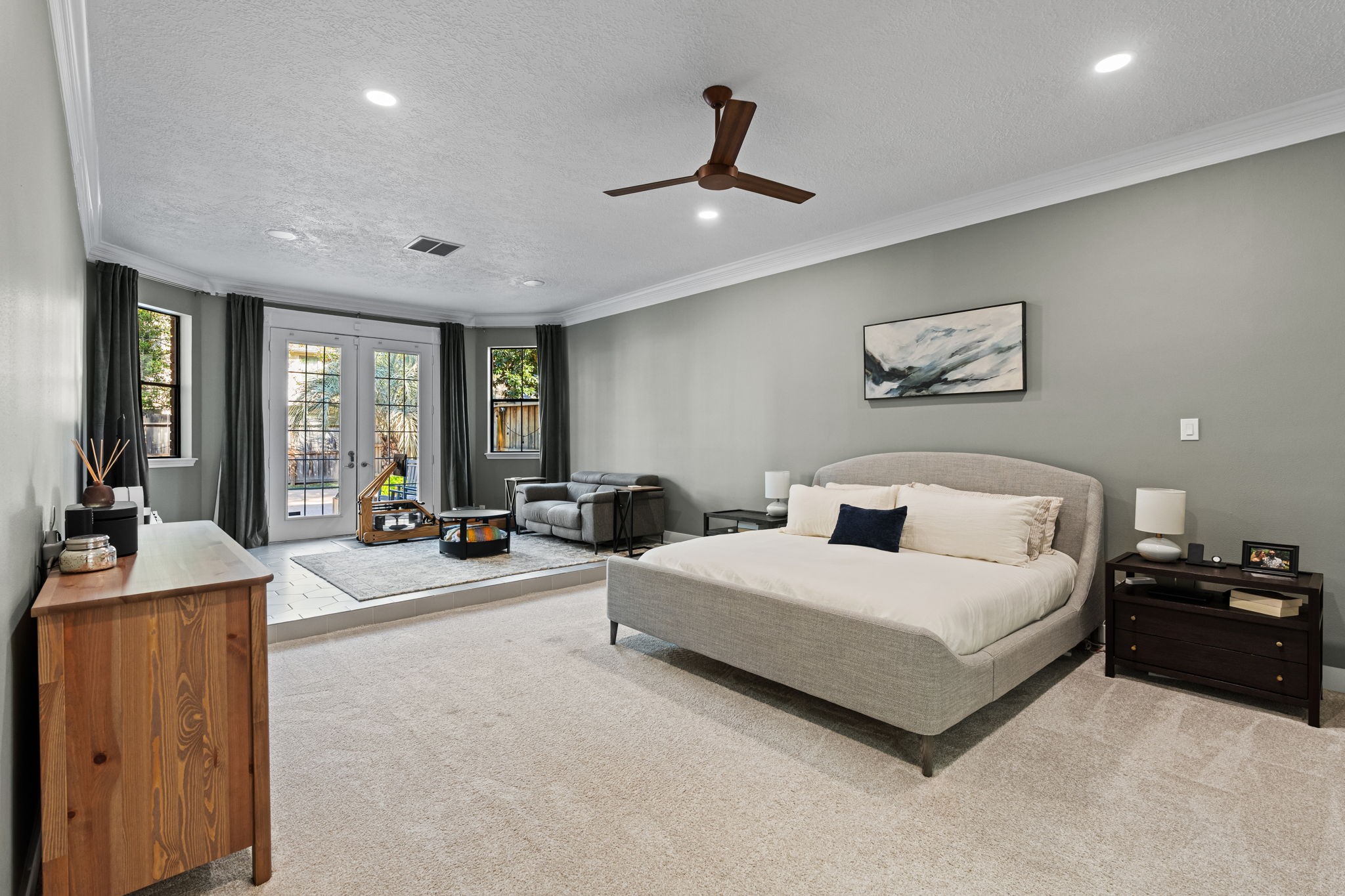 9410 Windrush Drive Spring, TX 77379 - Photo 19 of 50 a spacious bedroom with a bed a couch and large windows