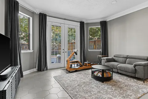 a living room with furniture a flat screen tv and a window